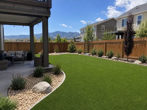 Finished artificial turf backyard installation in Denver with patio and Colorado landscape