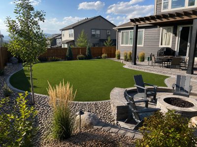 Aspirational Denver backyard outdoor living space with artificial turf and fire pit patio