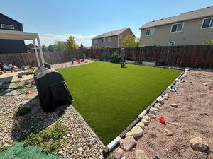 Finished backyard artificial turf with rock edging in a Denver yard